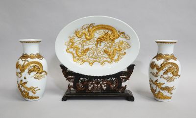 three vases and a plate sitting on a table