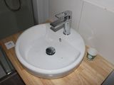 a white sink sitting on a wooden counter in a bathroom
