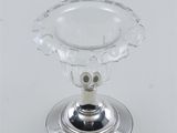 an image of a glass candle holder on a silver plate
