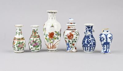 Plusieurs vases aux motifs variés sont alignés sur une surface grise
