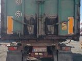 a green dump truck that is parked on the side of the road