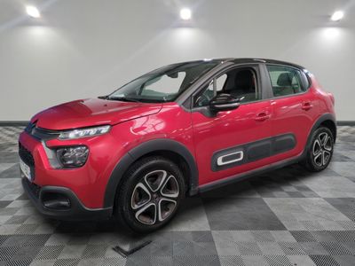 Une voiture rouge est garée dans une pièce dont le sol est en damier.