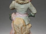 figurine of a woman sitting on top of a tree stump