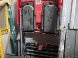 une échelle appuyée contre un mur, à côté d'une pile de chaises
