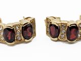 a pair of gold and garnet stone earrings