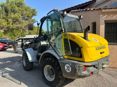 un tracteur jaune garé devant un bâtiment