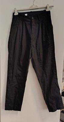 black pants hanging on a hanger on a wall in a room