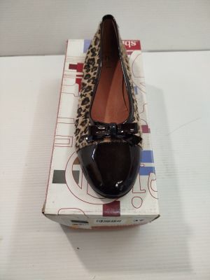 quelqu'un porte une paire de chaussures à imprimé léopard posée sur une boîte