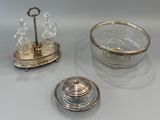 two silver plated dishes and a glass bowl on a table