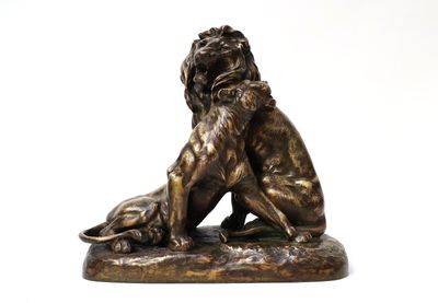bronze statue of a lion and a dog on a white background