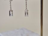 gold plated jewelry stand with a pair of earrings hanging from it
