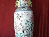 a vase that is sitting on a table in front of a red curtain