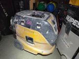 a yellow and black vacuum cleaner in a garage