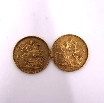 two gold coins sitting side by side on a white surface