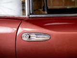 a close up of a red car with a clock in the background