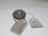 une photo d'une bague en argent à laquelle est attachée une étiquette