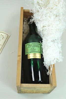 une bouteille de vin dans un coffret en bois à côté d'une bouteille de vin