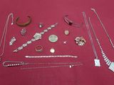 many different necklaces and bracelets laid out on a table