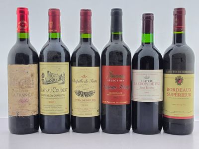 six bouteilles de vin sont alignées sur une table