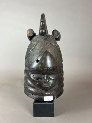 un gros plan d'un masque en métal posé sur un socle noir