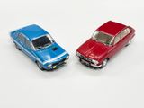 two toy cars sitting next to each other on a white surface