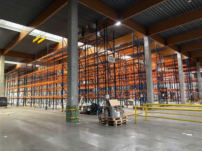 un grand entrepôt rempli d'étagères et de palettes