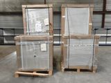 trois palettes de verre sont empilées sur des palettes dans un entrepôt