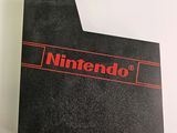 a close up of a nintendo logo on a black card