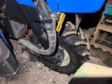 a blue tractor with a big tire in a garage
