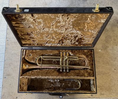 an old trumpet in a case on the floor