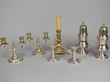 a lot of silver candles that are sitting on a table