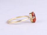 a close up of a ring with an orange stone on it
