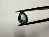 someone is holding a pair of pliers with a green diamond on it