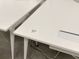 deux bureaux blancs équipés d'ordinateurs dans un bureau