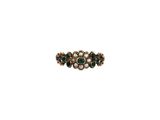 un gros plan d'une bague ornée de pierres vertes et de perles