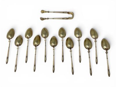 six spoons and a spoon rest in a row on a white surface