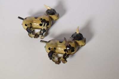 pair of antique brass dog figurines on a white surface