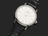 gros plan d'une montre sur une surface noire avec un fond noir