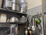 de nombreuses casseroles et poêles sur les étagères de la cuisine