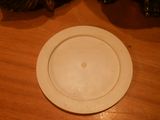 a white plate sitting on a wooden table with a christmas tree in the background