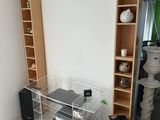 a room with a tv, speakers, and a shelf in it