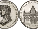 an old coin with a woman ' s head and a building in the background