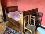a bed and a chair in a room with a red wall