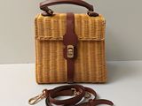 sac en osier marron avec une anselle en cuir marron sur un fond blanc