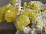 a close up of a piece of rock with yellow crystals on it