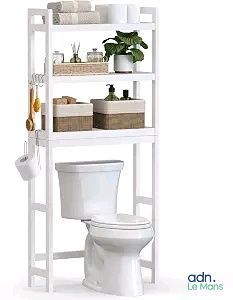 des toilettes blanches surmontées d'une étagère, à côté d'une plante en pot