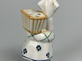 a small figurine of a woman holding a basket