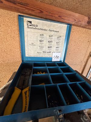 une boîte bleue contenant des outils, posée sur une table