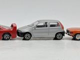 five toy cars lined up in a row on a white surface