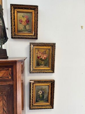 four paintings on the wall above a dresser in a room